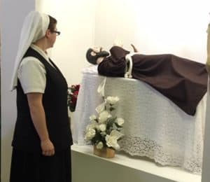 Novice Sister Clare Rose before statue of St. Francis of Asissi